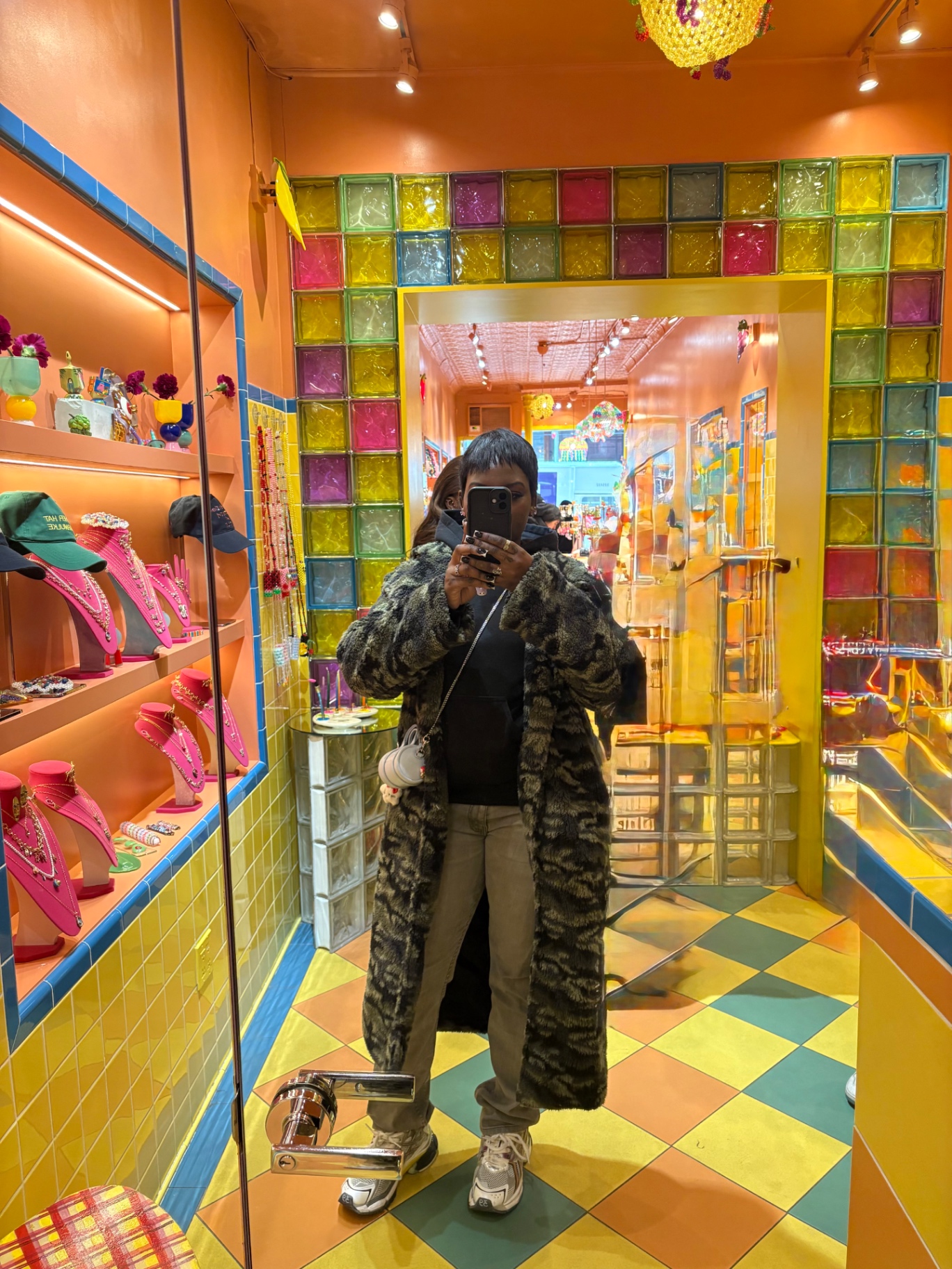 Jem in a mirror inside a colourful glass-block shop